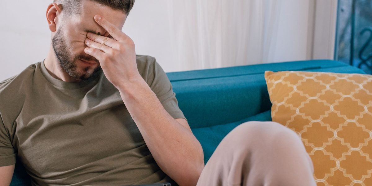 A person looks frustrated while using a device, reflecting a poor online experience with a difficult website.