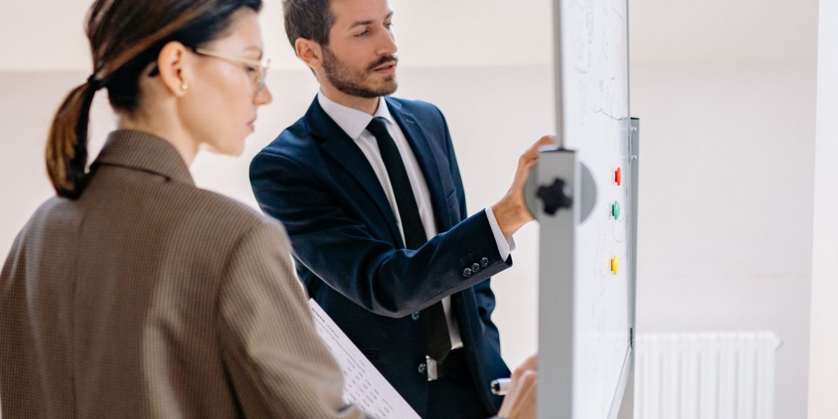 A team collaborating around a whiteboard, illustrating the structured planning phase for a successful website launch or migration.