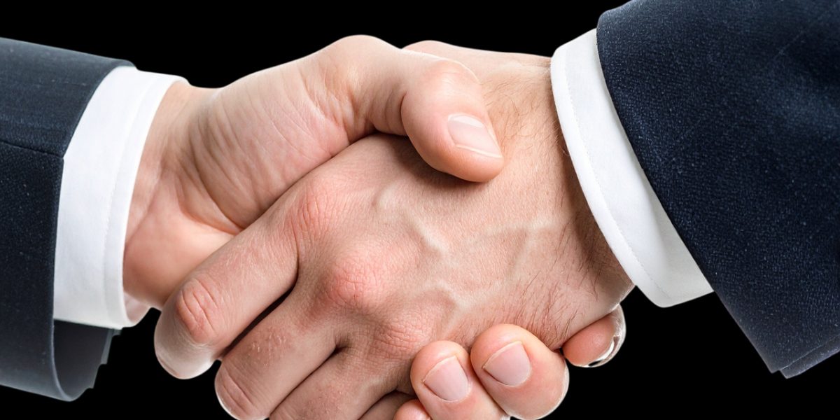 Two professionals engage in a handshake, symbolizing the establishment of trust and a shared agreement in a legal context.