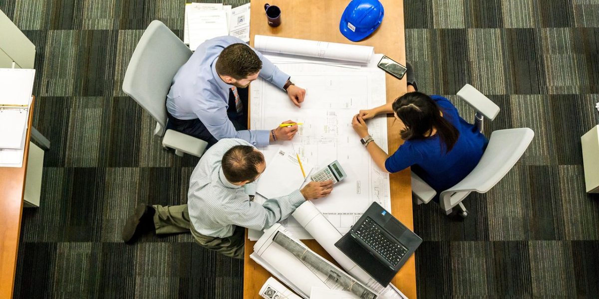 A legal team collaborating around a whiteboard, discussing strategic plans or geographical operational scale.