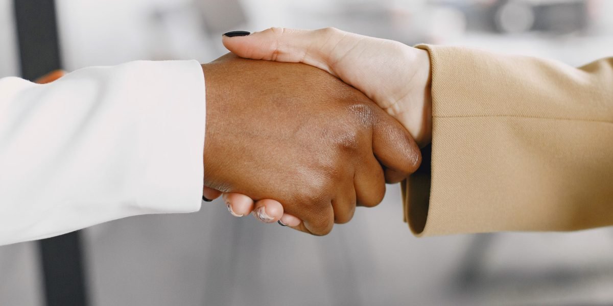 A handshake seals an agreement between academic and industry leaders, symbolizing collaboration in legal technology education.