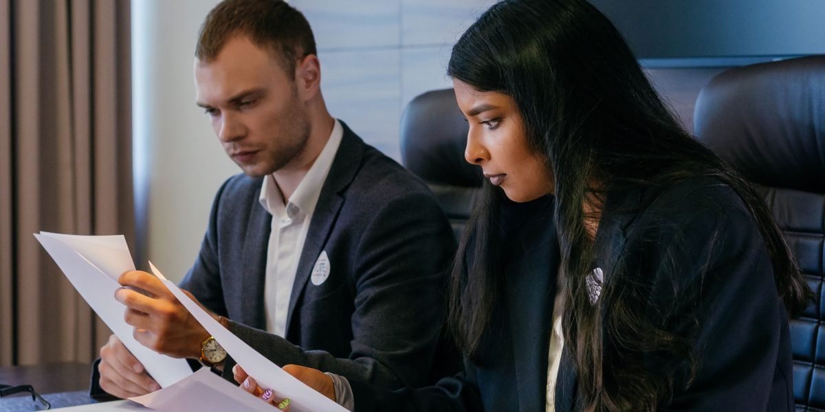 Business partners diligently reviewing legal documents and firm profiles.