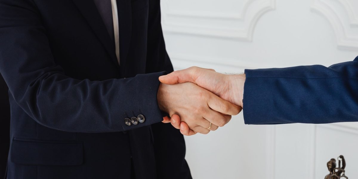 Two professionals shaking hands, symbolizing the successful launch and protection of a new brand or partnership.