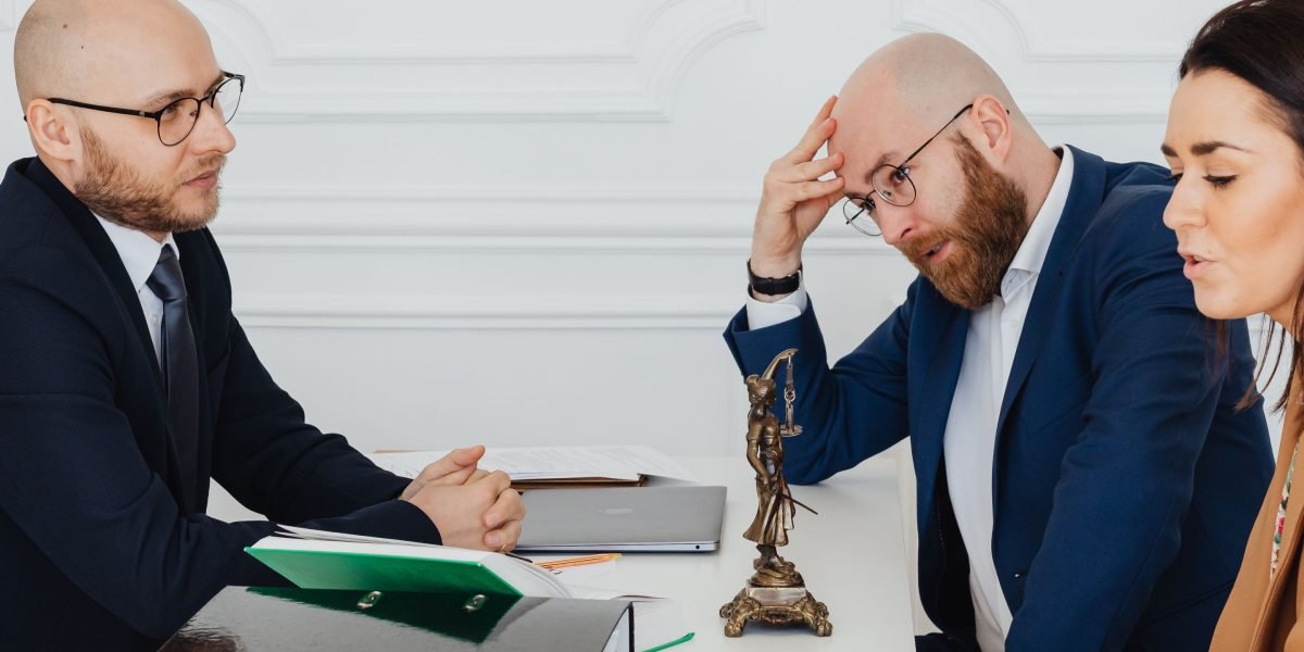 Individuals shaking hands or reaching an agreement with a neutral party present, representing a successful mediation or informal resolution.