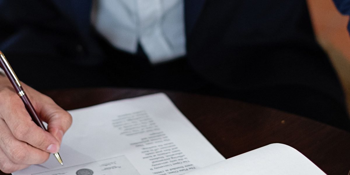 A person cross-referencing documents and online information to verify a professional's credentials and background.