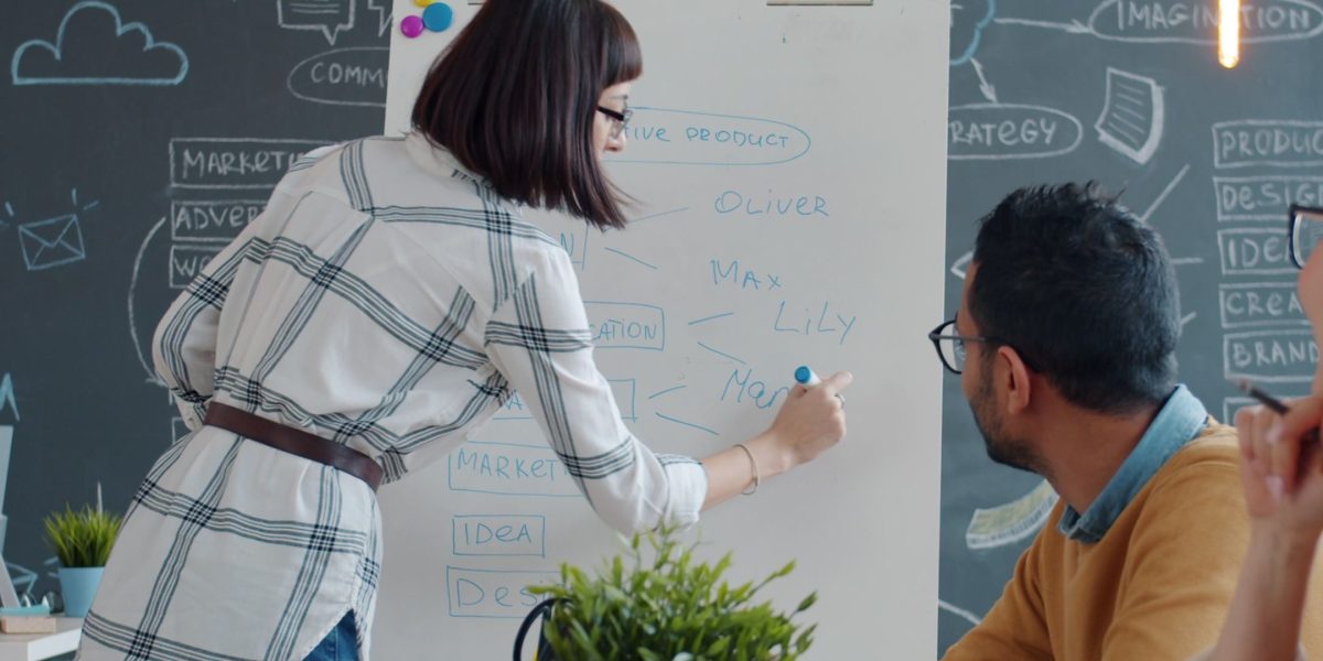 A diverse team actively brainstorming on a whiteboard, symbolizing innovation and adaptation to new technologies in the legal field.