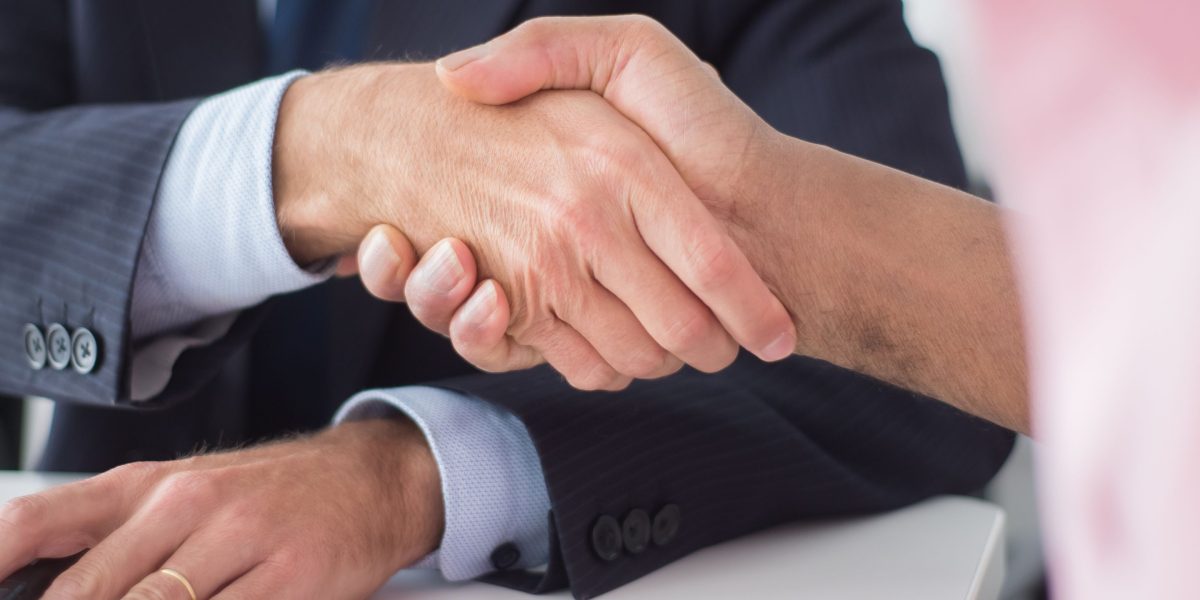 Business partners formalizing an agreement with a handshake after a successful meeting.